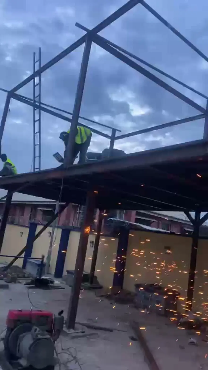 Crew welding a steel canopy frame at dusk on a Solid Imaginations site